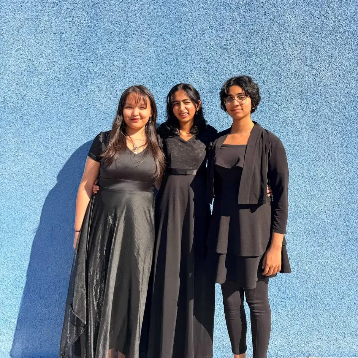 Three Hamilton honor choir singers in concert black outside a performance hall